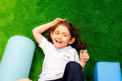 Pequeña niña sonriendo mientras juega feliz en las instalaciones con seguridad de Colegios Connections Cayalá